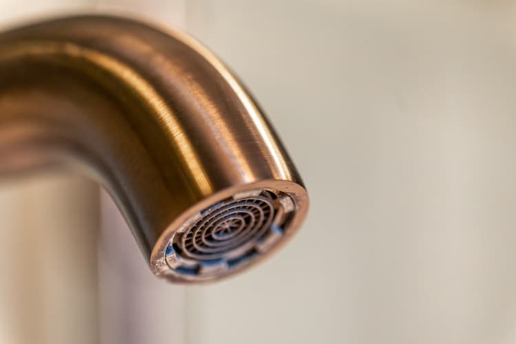 metallic faucet head with circular pattern
