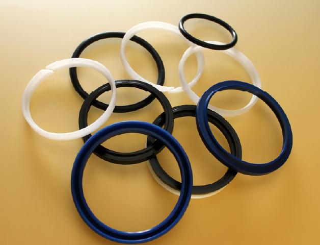 Silicone rubber O-rings in white, black, and blue on a yellow background