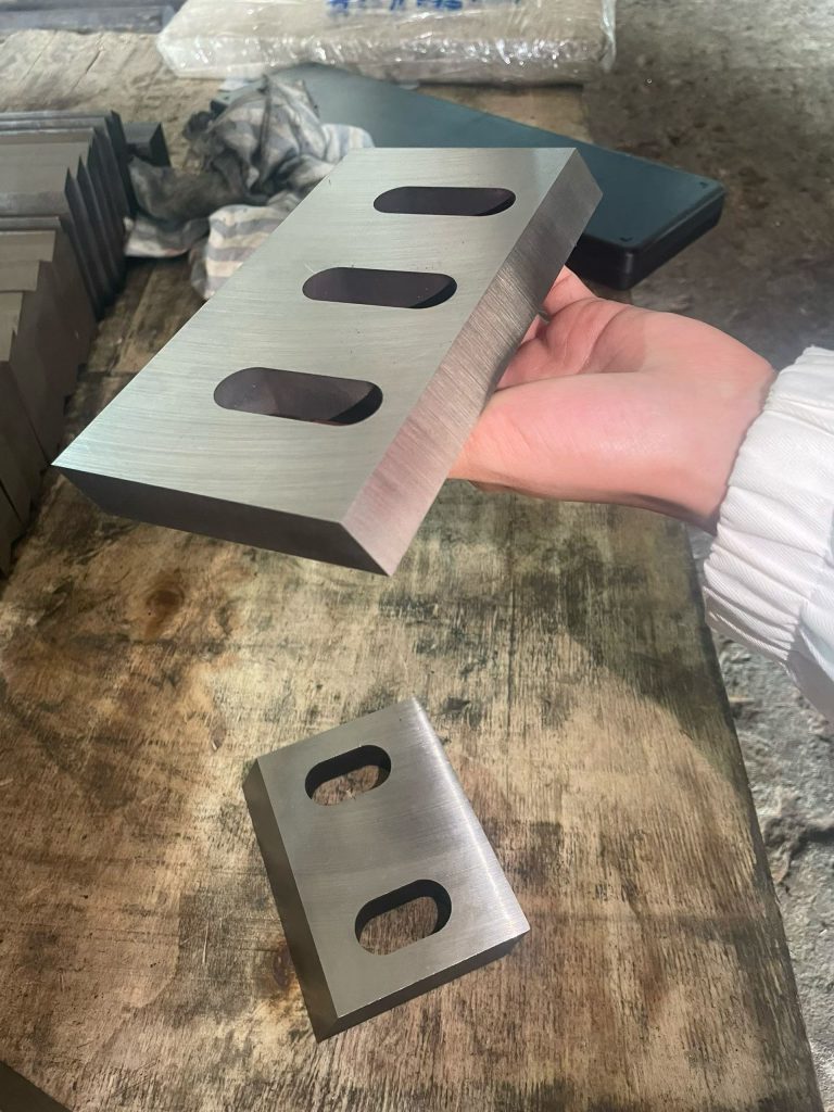 Precision-ground crusher blades arranged on a workshop bench